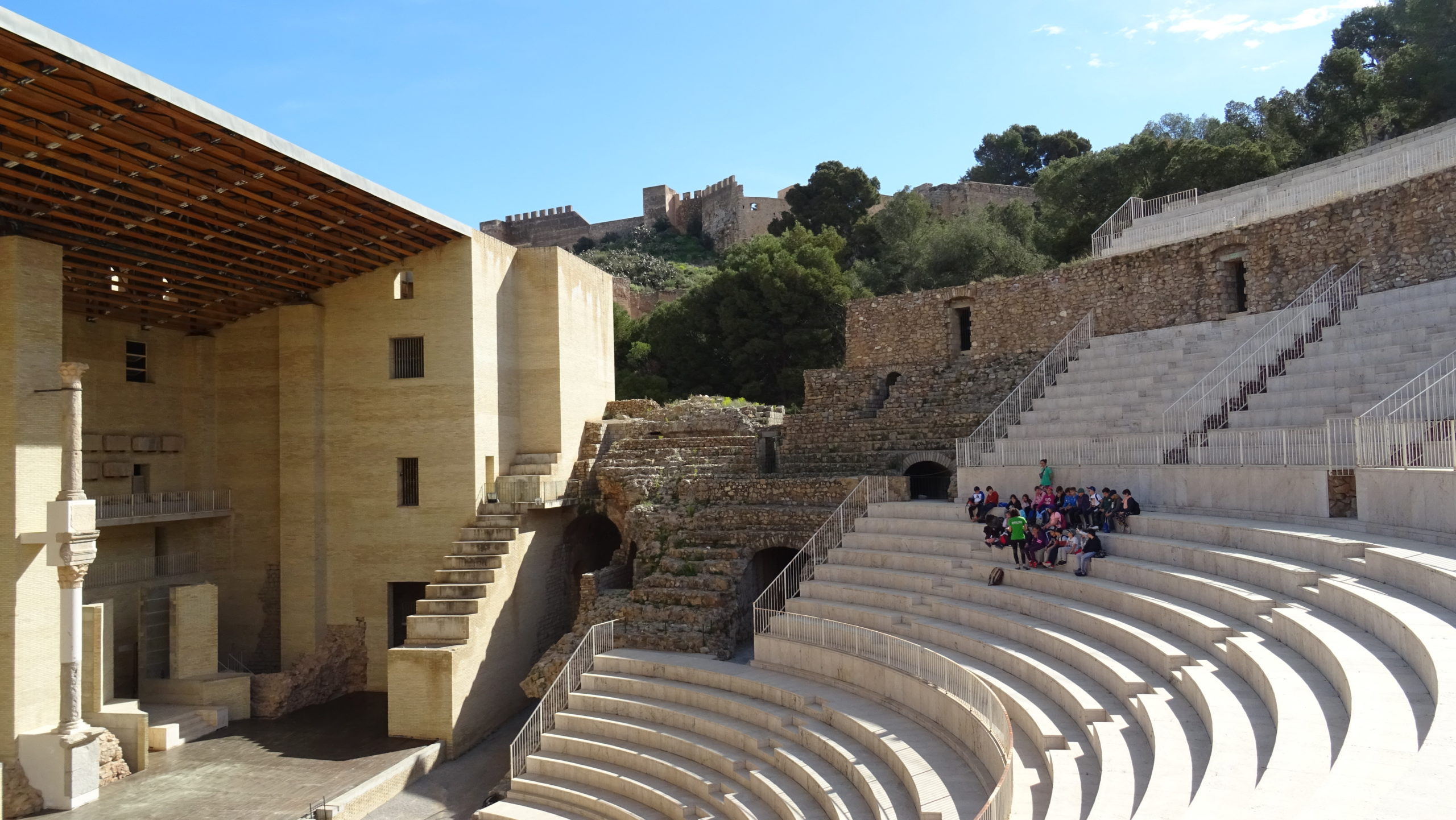 Roman Theatre of Sagunto, Spain, with its semicircular seating area and the historic Sagunto Castle visible on the hill above.